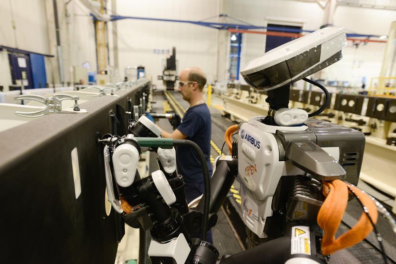 OUvrier et robot dans une usine