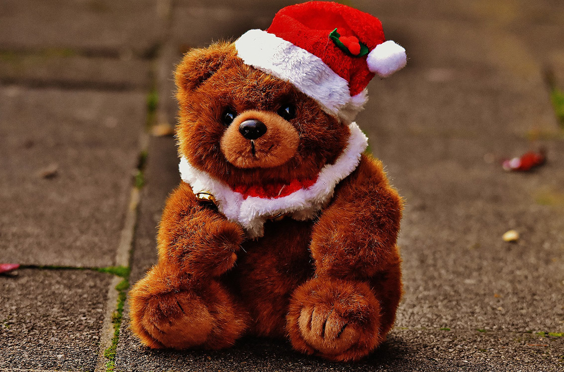 Gros plan d’un ours en peluche en costume de Père Noël
