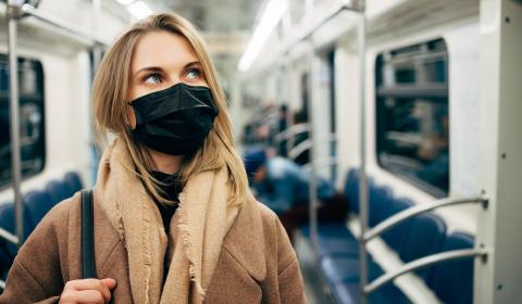 Une jeune femme portant un masque en tissus dans un transport en commun métro ou train