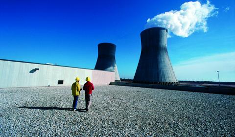 Deux techniciens nucléaires aux abords des cheminées d'une centrale