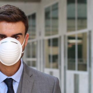 Jeune cadre portant un costume et un masque anti-pollution