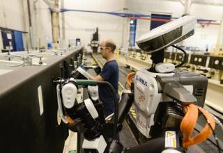 OUvrier et robot dans une usine