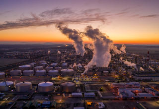 Vue au lever du soleil de cheminées sur un site pétrochimique