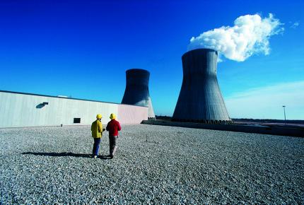 Deux techniciens nucléaires aux abords des cheminées d'une centrale