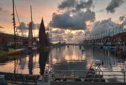 Voiliers de la course Transat Jacques Vabre à quai dans la marina, au soleil couchant